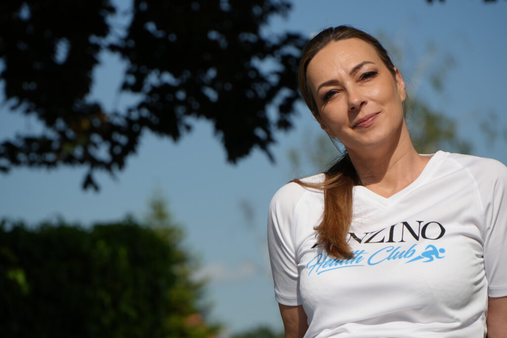 Cornelia, ganzheitliche Kosmetikmeisterin und Mentorin für testbasierte Gesundheit, sitzt entspannt im Freien – Symbol für ortsunabhängiges Arbeiten, Freiheit und Selbstbestimmung.